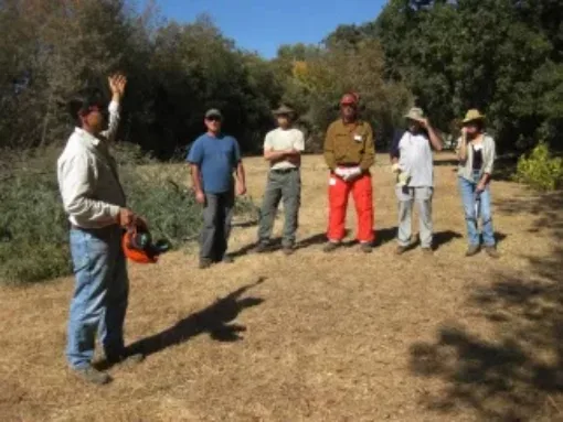 A group of people listening to a person speaking outside